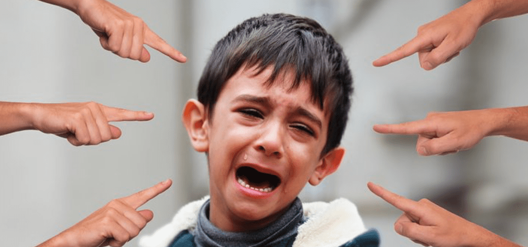 Young boy crying surrounded by multiple hands pointing fingers at him; image by geralt, via Pixabay.com.