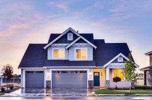 Two-story house at dusk with lights on; image by Manish Dogra, via Unsplash.com.