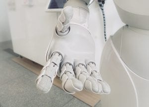 Close-up of white robot arm; image by Franck V., via Unsplash.com.