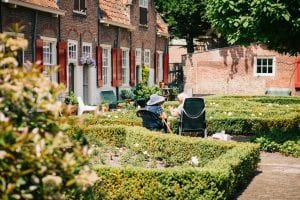 Two women sitting in front of house; image by Joyce Huis, via Unsplash.com.