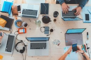 People at a table with laptop computers; image by Marvin Meyer, via Unsplash.com.