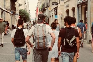 Group of teenagers wearing backpacks walking away from camera; image by Rich Smith, via Unsplash.com.