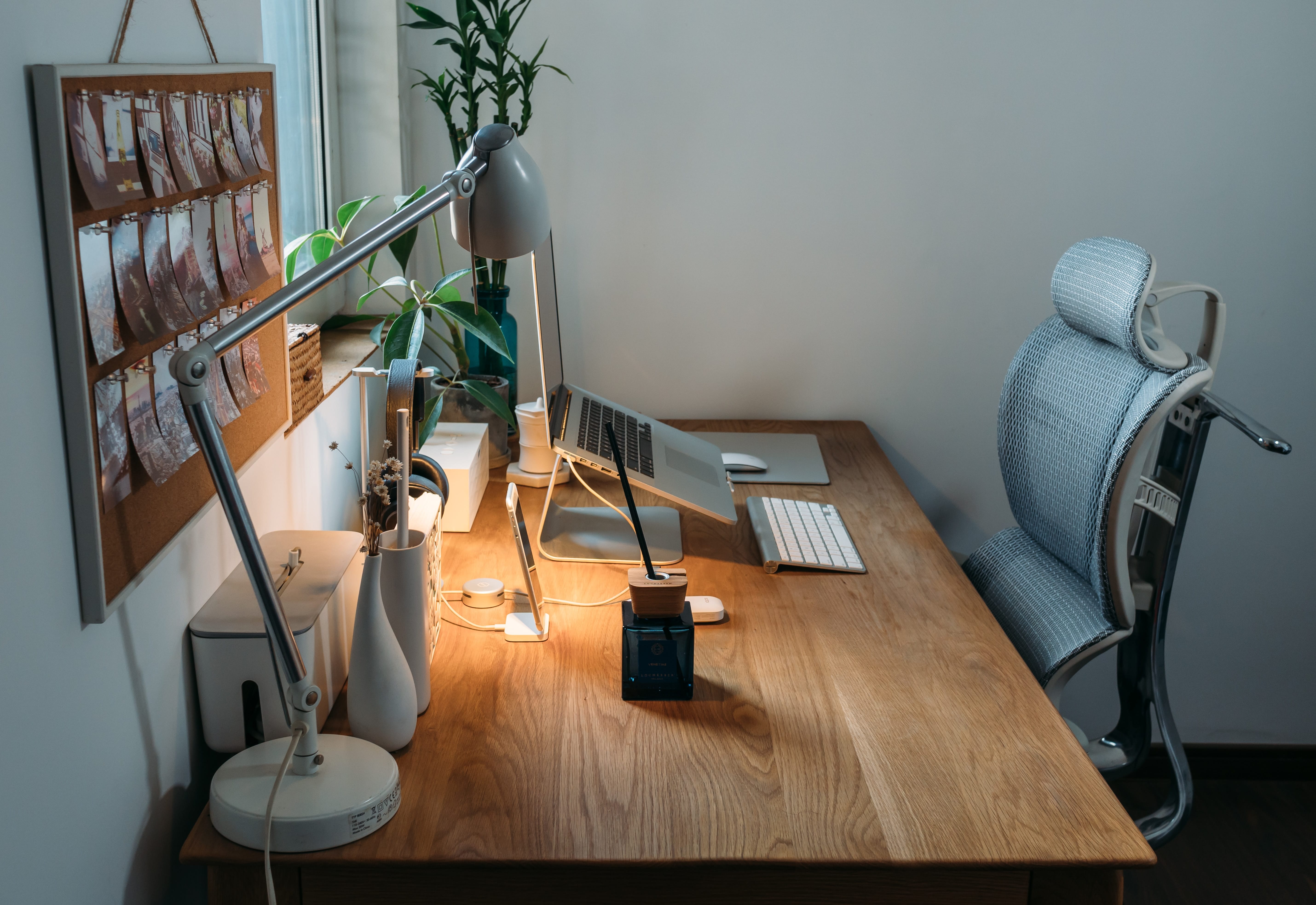 Desk with computer, lamp, and personal effects; image by Samule Sun, via Unsplash.com.