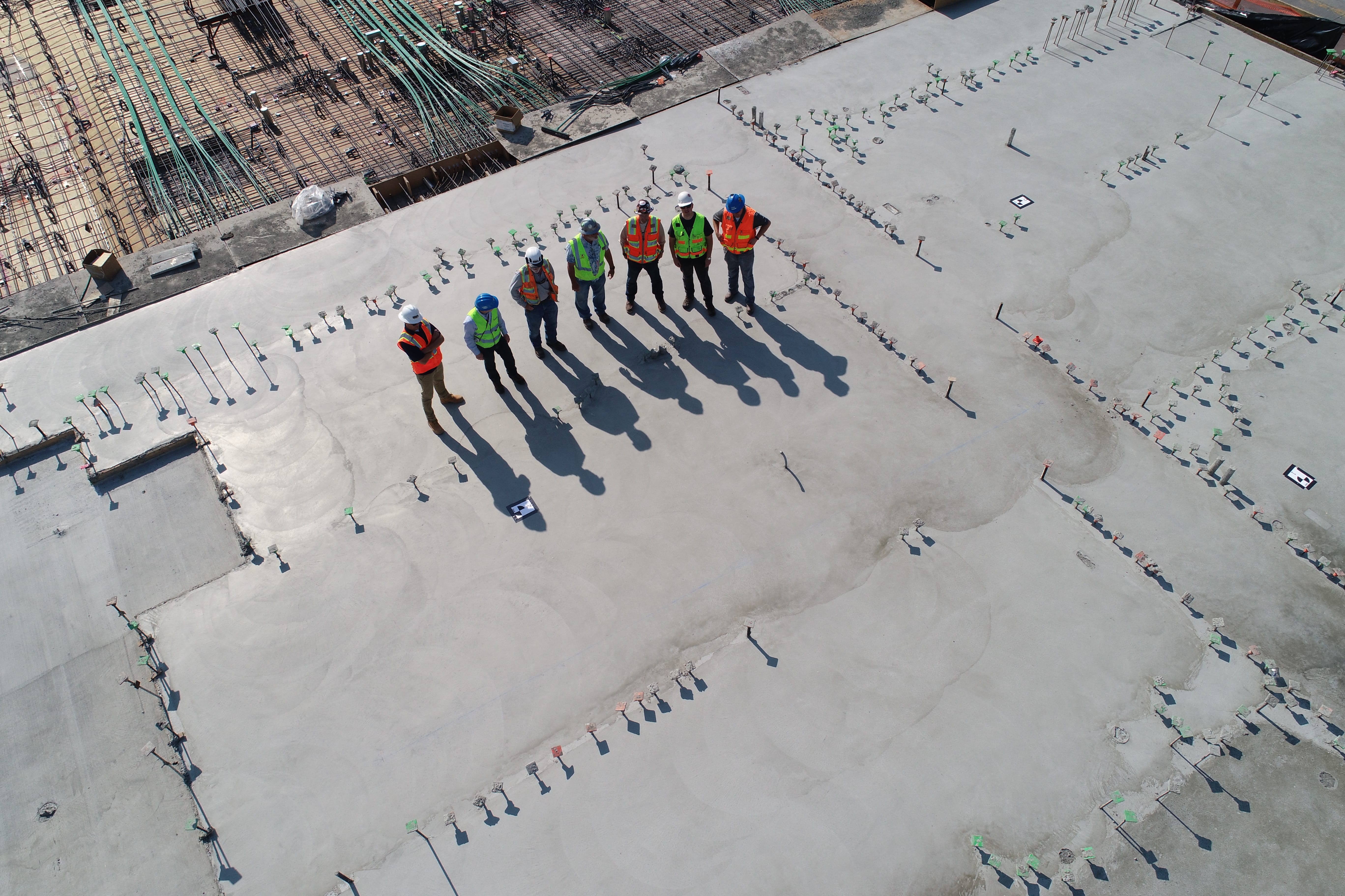 Seven construction workers standing on a white field; image by Scott Blake, via Unsplash.com.