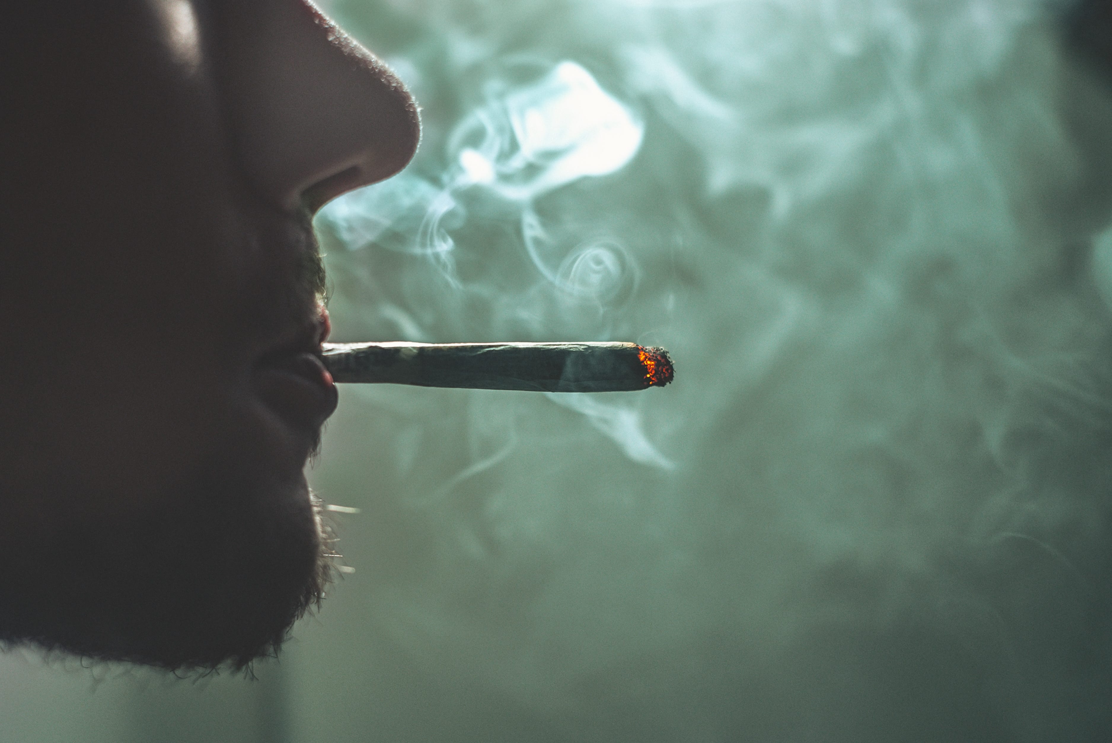 Man smoking a joint; image by GRAS GRÜN, via Unsplash.com.