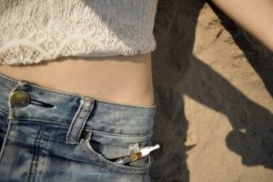Vape pen sticking out of pocket of woman’s jeans; image by Maria Badasian, via Unsplash.com