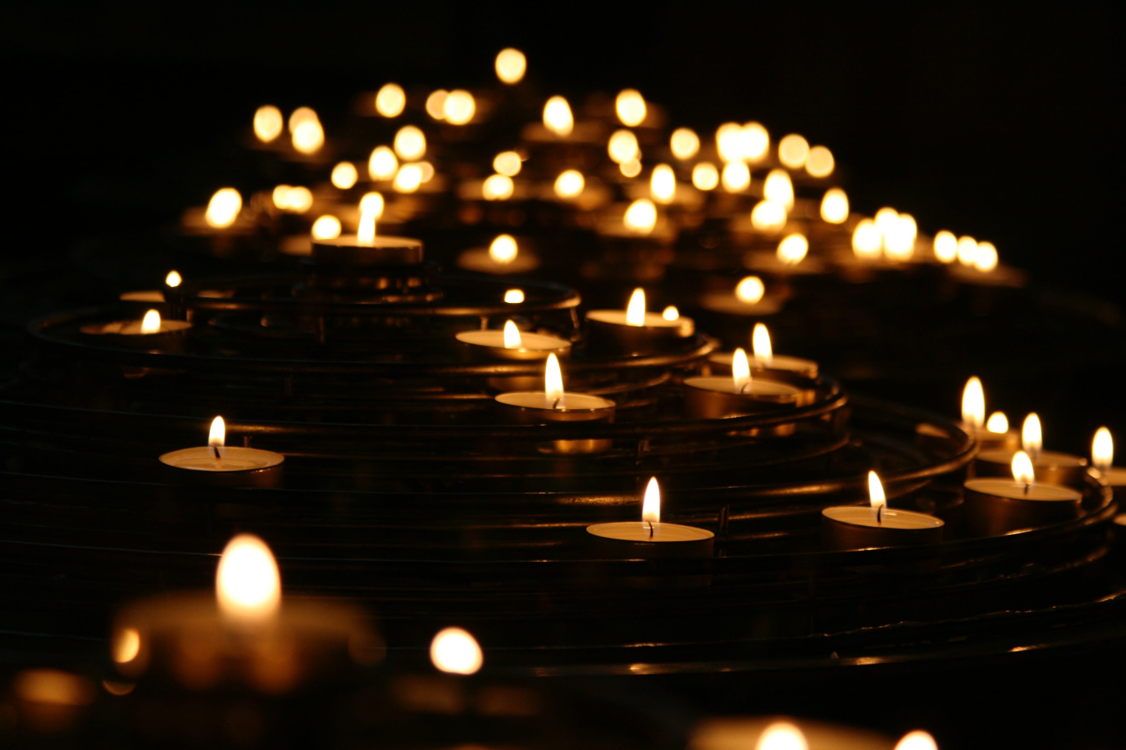Low-angle photo of lighted candles; image by Mike Labrum, via Unsplash.com.