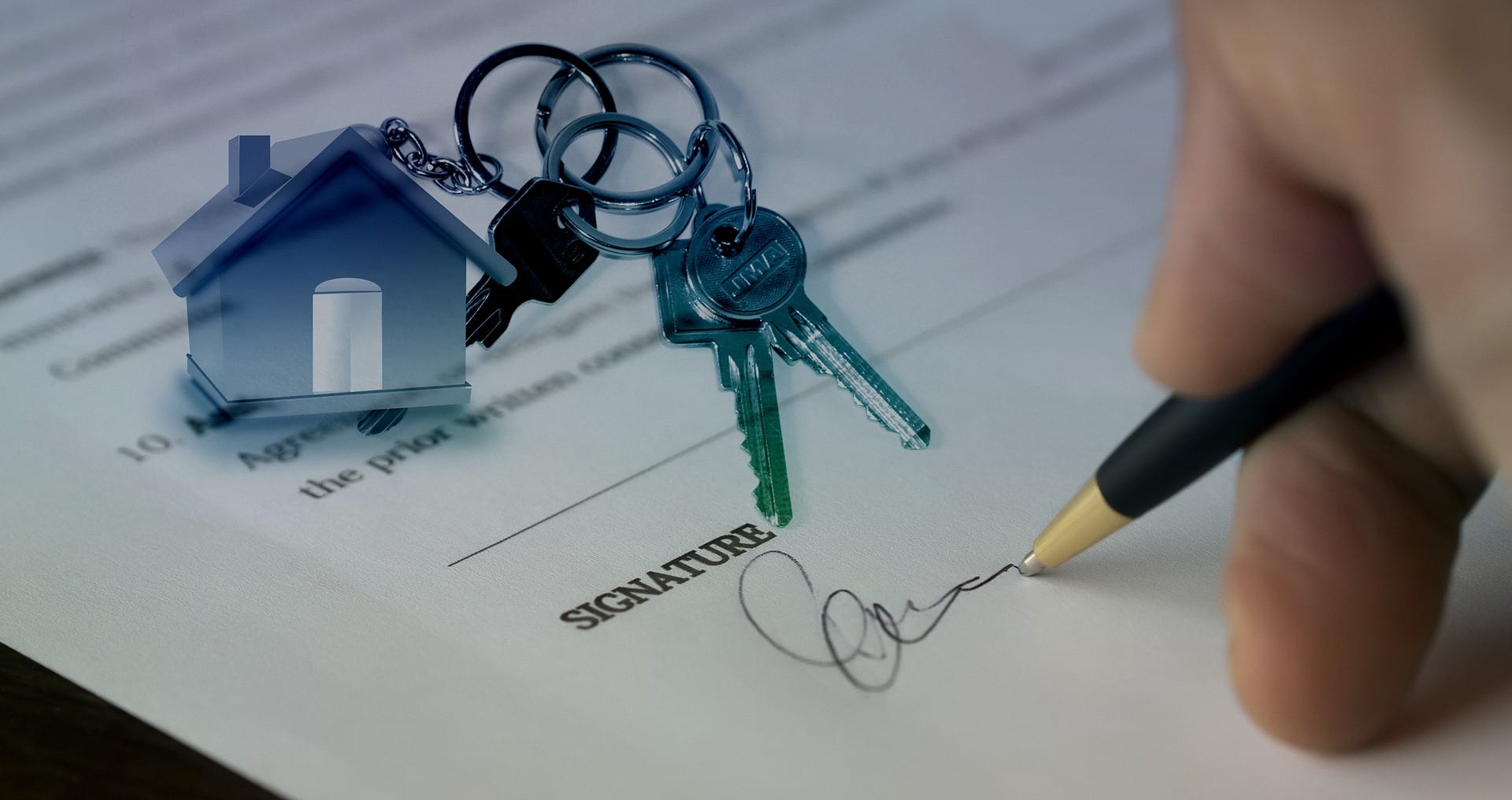 Keyring with small house on it sitting on top of purchase contract as man signs it; image by geralt, via Pixabay, no changes made.