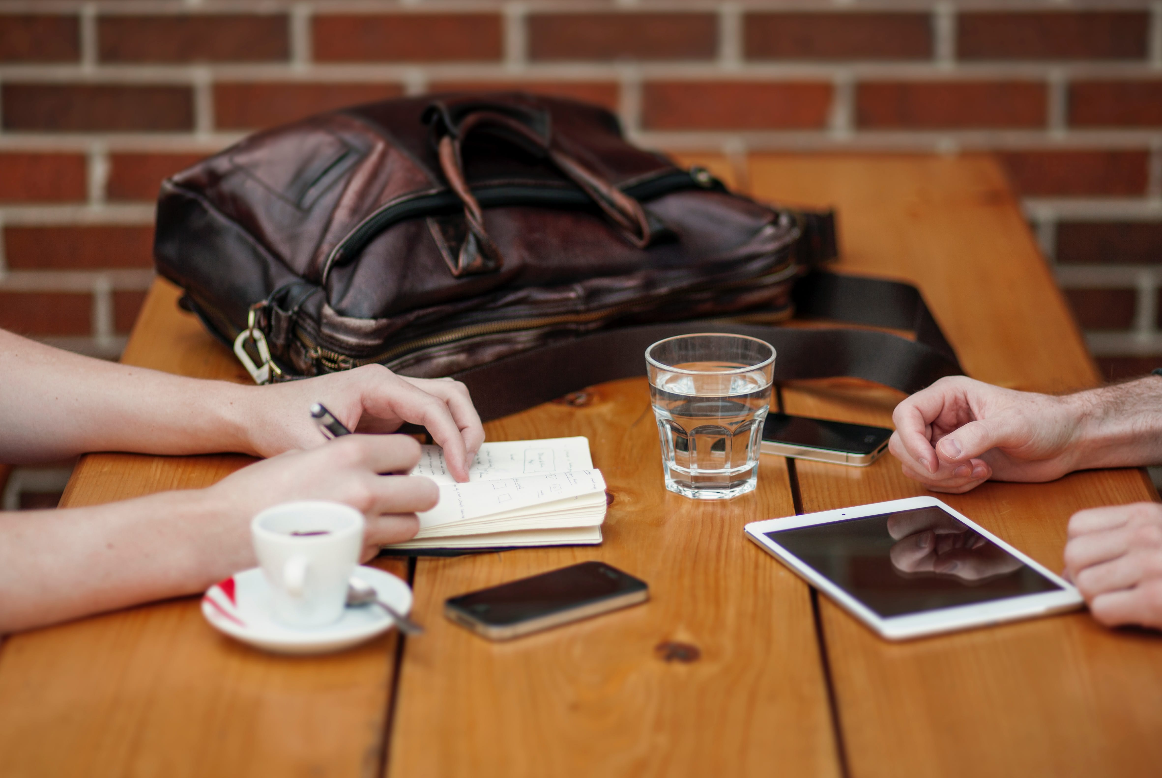 Two people meeting with iphone and ipad; image by Alejandro Escamilla, via Unsplash.com.