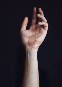 Man with bandage on palm of hand; image by Brian Patrick Tagalog, via Unsplash.com.