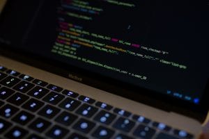 MacBook Pro with images of computer language codes; image by Caspar Camille Rubin, via Unsplash.com.