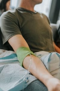 Man receiving an IV; image by Creators Collective, via Unsplash.com.