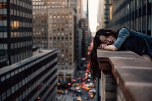 Woman leaning on top building rail during daytime; image by Hernan Sanchez, via Unsplash.com.