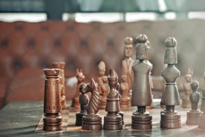 Chess pieces on board; image by Maarten van den Heuvel, via Unsplash.com.