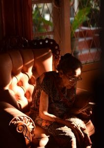 Woman reading in armchair; image by Yoshua Giri, via Unsplash.com.