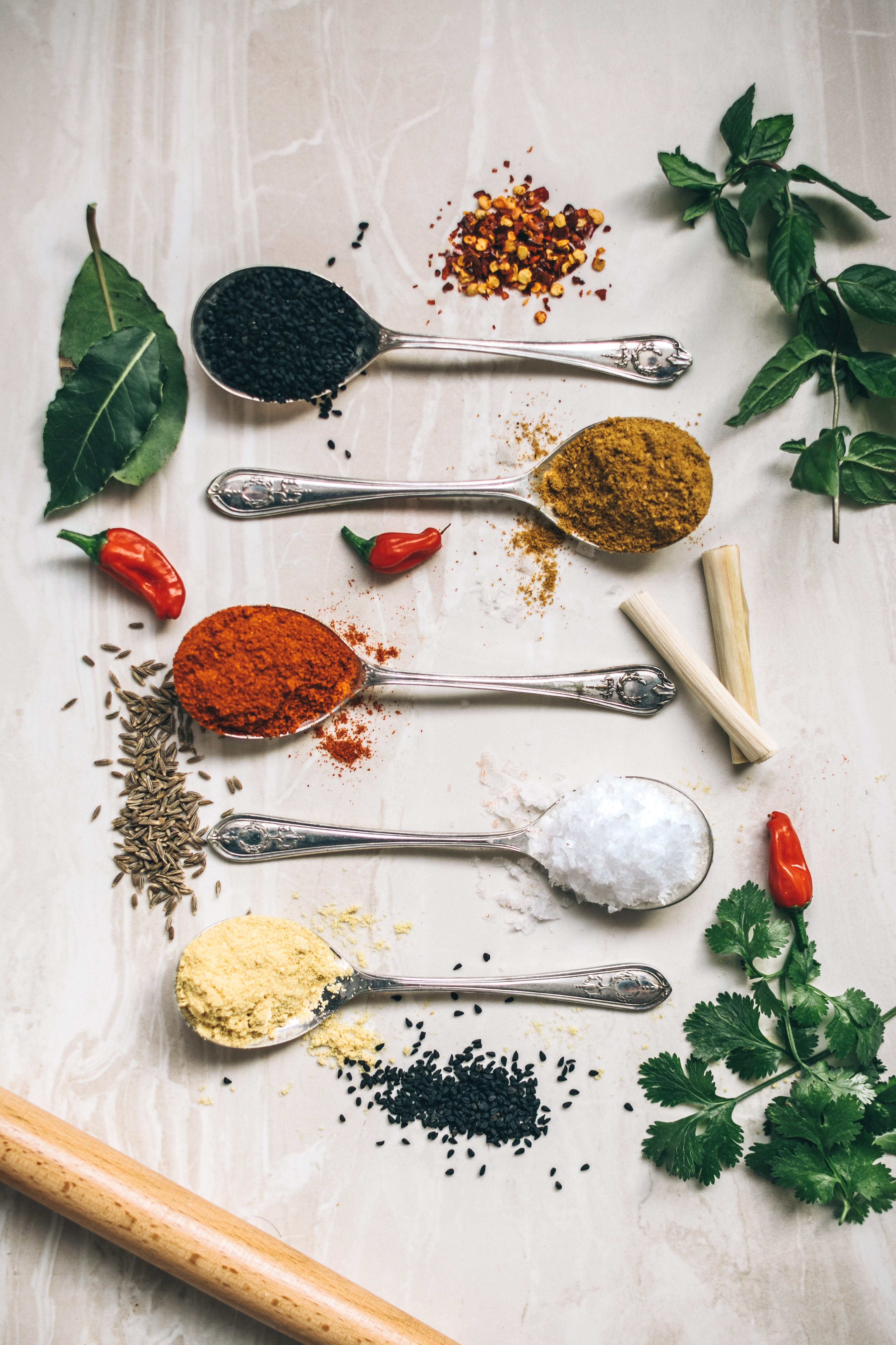 Five spoons with various powders, surrounded by herbs; image by Calum Lewis, via Unsplash.com.