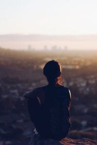 Woman sitting on brown rock during daytime; image by Christopher Sardegna, via Unsplash.com.