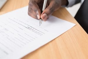 Man writing on white paper; image by Cytonn Photography, via Unsplash.com.