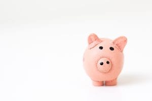 Pink pig figurine on white surface; image by Fabian Blank, via Unsplash.com.