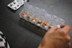Person filling daily medication dispenser; image by Laurynas Mereckas, via Unsplash.com.