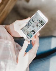 Person looking at social media on smartphone; image by Georgia de Lotz, via Unsplash.com.