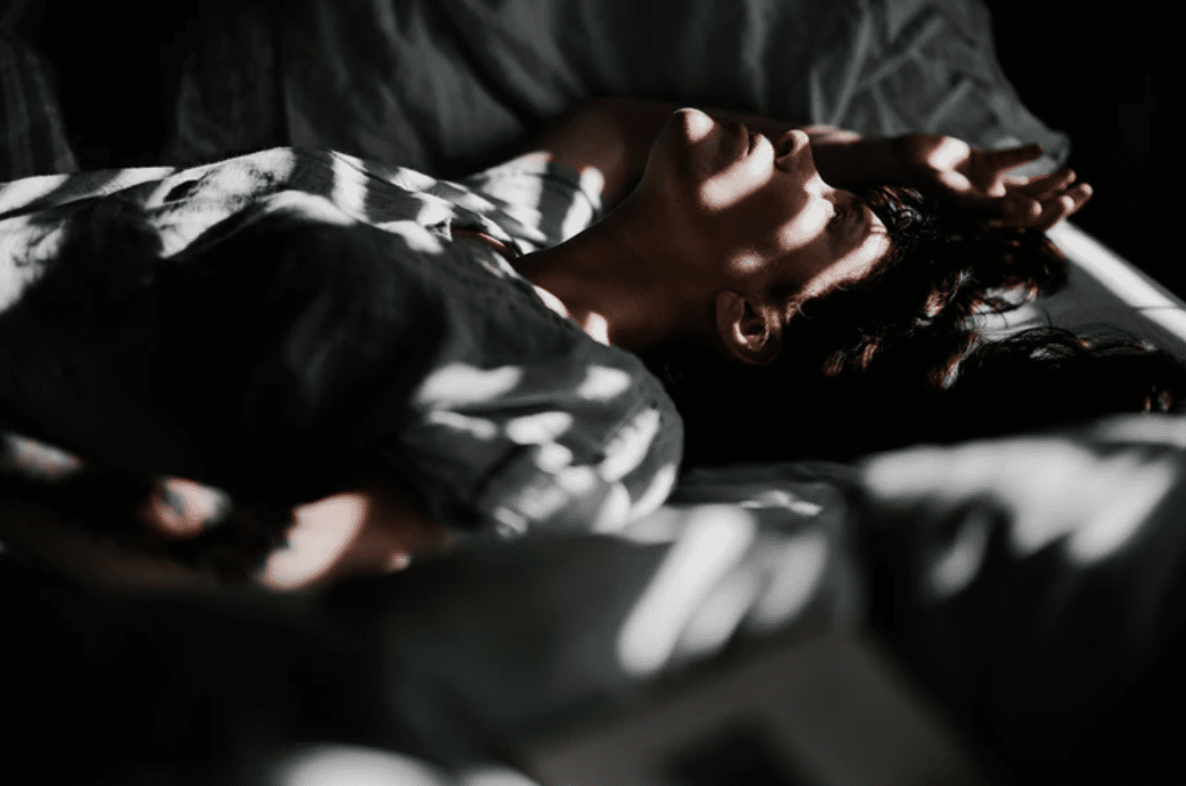 Woman on bed in sunlight and shade; image by Annie Spratt, via Unsplash.com.