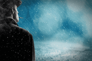 Man standing smoking a cigarette as snow falls; image by Pixel2013, via Pixabay.com.