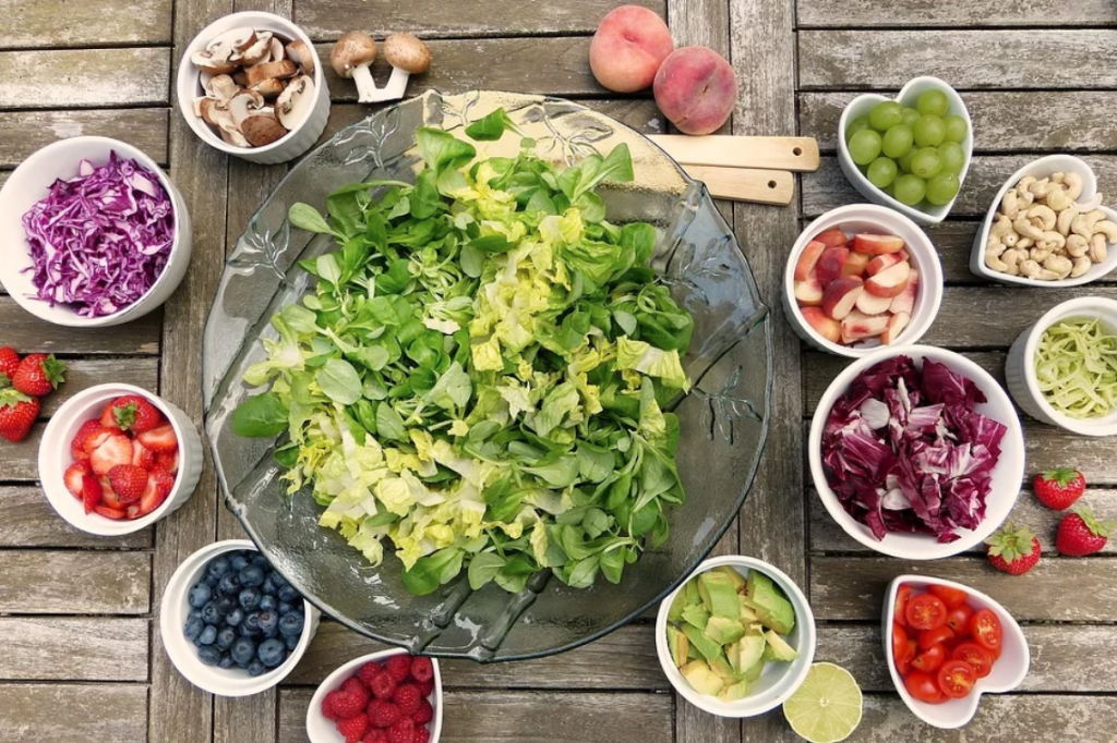 Big bowl of shredded lettuce surrounded by smaller bowls of salad items; image by Silviarita, via Pixabay.com.