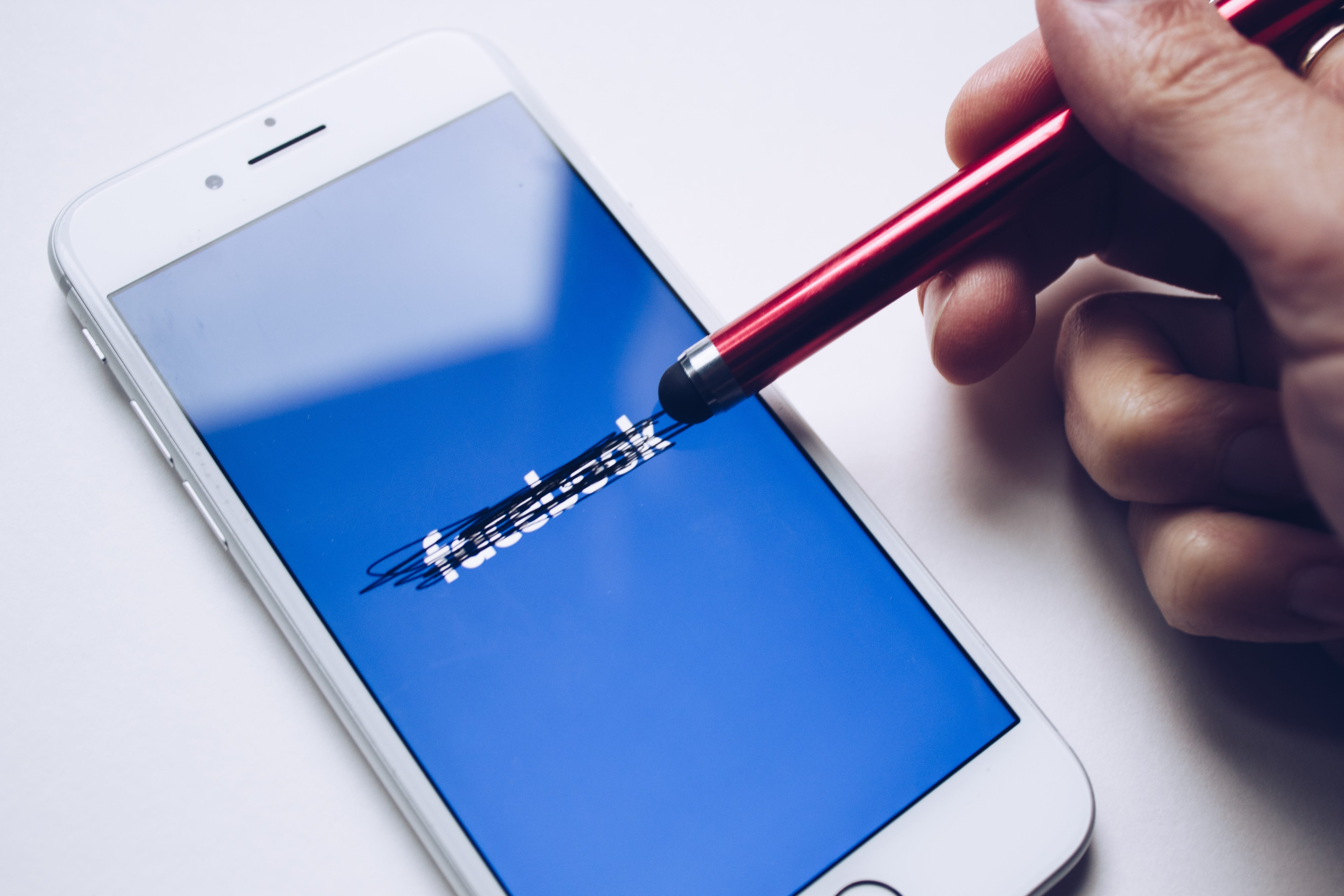 Person using stylus on smartphone to cross out Facebook; image by Thought Catalog, via Unsplash.com.