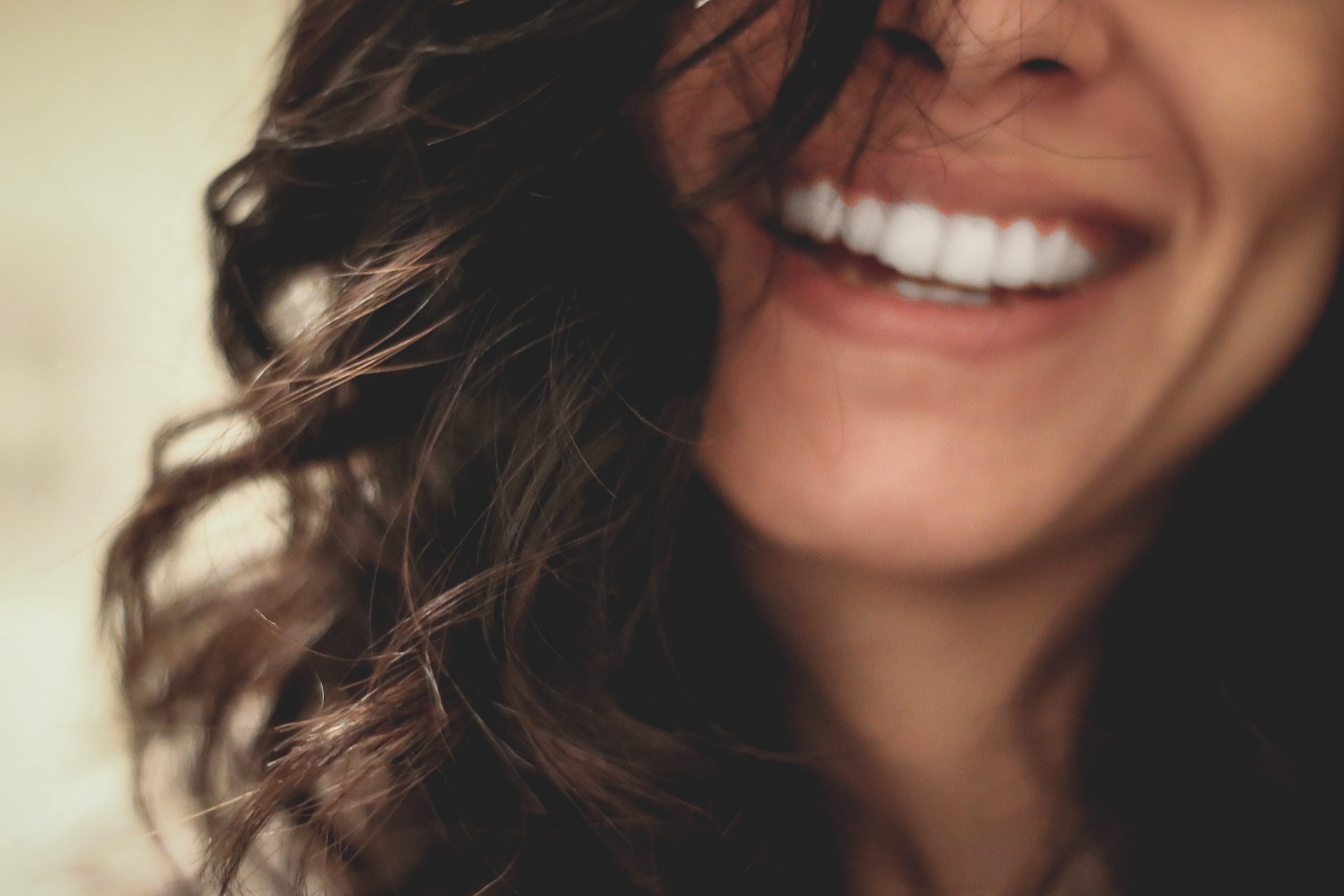 Woman smiling close-up photography; image by Lesly Juarez, via Unsplash.com.