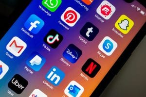 iPhone displaying social media apps; image by Kon Karampelas, via Unsplash.com.