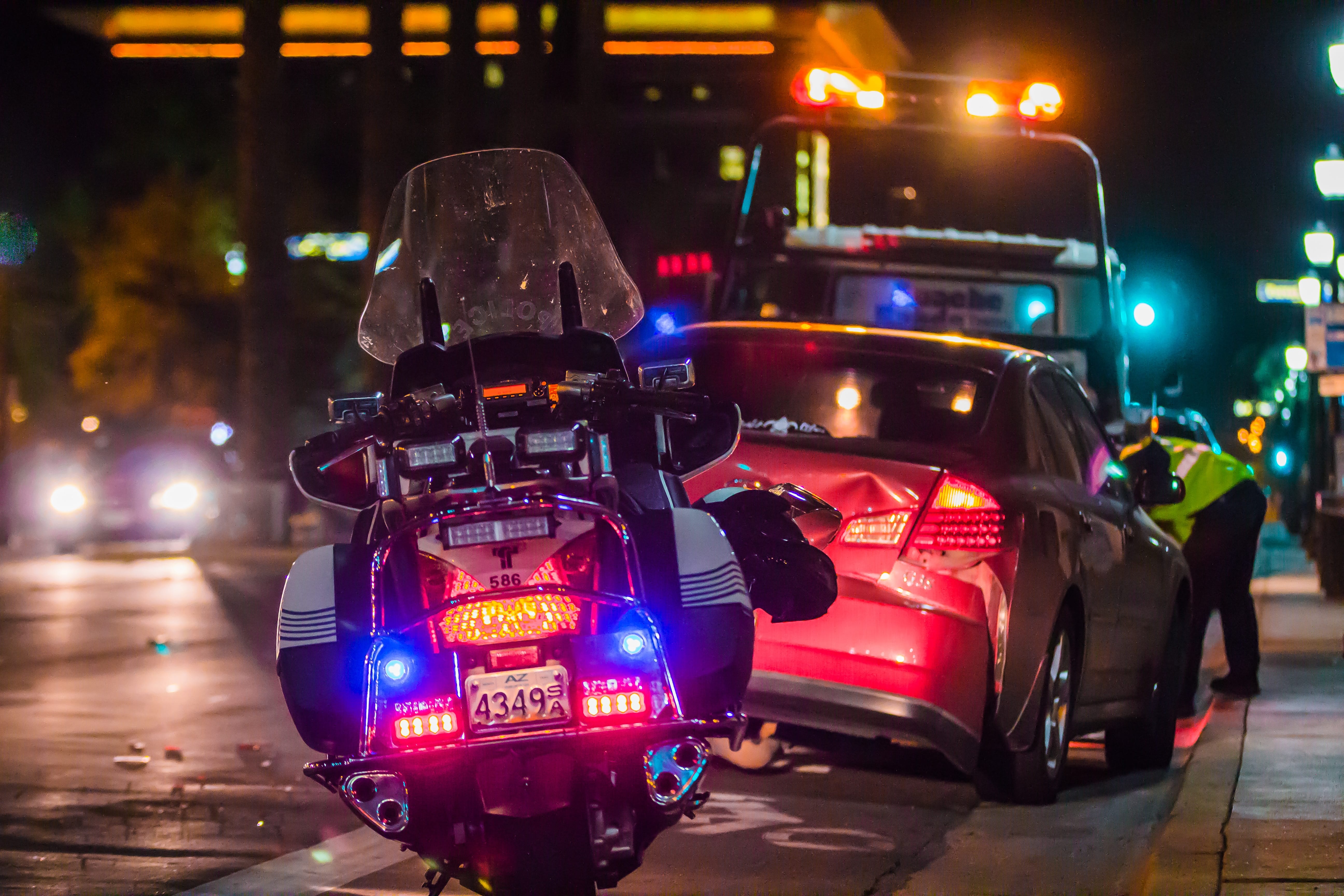 Police officer leaning in window of car after accident; image by Matt Chesin, via Unsplash.com.