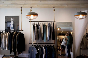 Racks of clothing in shop; image via Clark Street Mercantile, via Unsplash.com.
