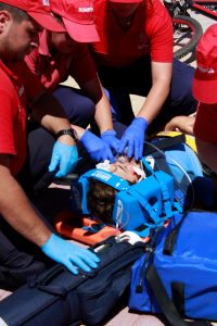 People performing first aid on an injured man; image by Daniela Santos, via Unsplash.com.