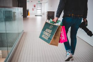 Man with shopping bags and camera; image by Erik Mclean, via Unsplash.com.