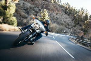 Man taking curve on a motorcycle; image by Harley-Davidson, via Unsplash.com.