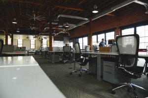 Open room full of workstations; image by Startup Stock Photos, via Pexels.com.