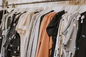 Clothing rack full of tops; image by Lauren Fleischmann, via Unsplash.com.