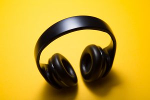 Wireless headphones with yellow background; image by Malte Wingen, via Unsplash.com.