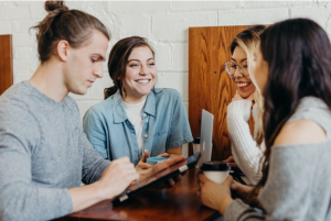 Group sitting at table with laptop and tablet and coffee; image by Brooke Cagle, via Unsplash.com.