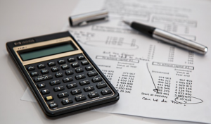 Calculator, pen, and budget worksheet; image by Pixabay, via Pexels.com.