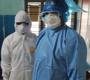 Two people wearing a full set of personal protective equipment.