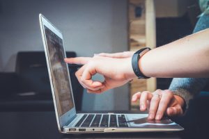 Two people reviewing something on a laptop; image by John Schnobrich, via Unsplash.com.