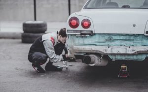 Man fixing car; image by Arseny Togulev, via Unsplash.com.