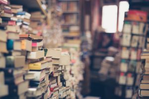 Piles of old books; image by Eli Francis, via Unsplash.com.