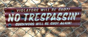 A No Trespassing sign which claims that violators will be shot, and survivors shot again.