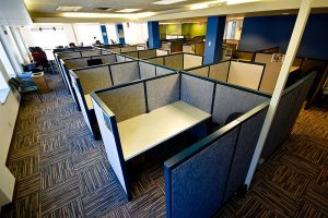 Office space divided into low cubicles, empty of people.
