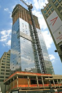 A glass-clad apartment high-rise during construction.