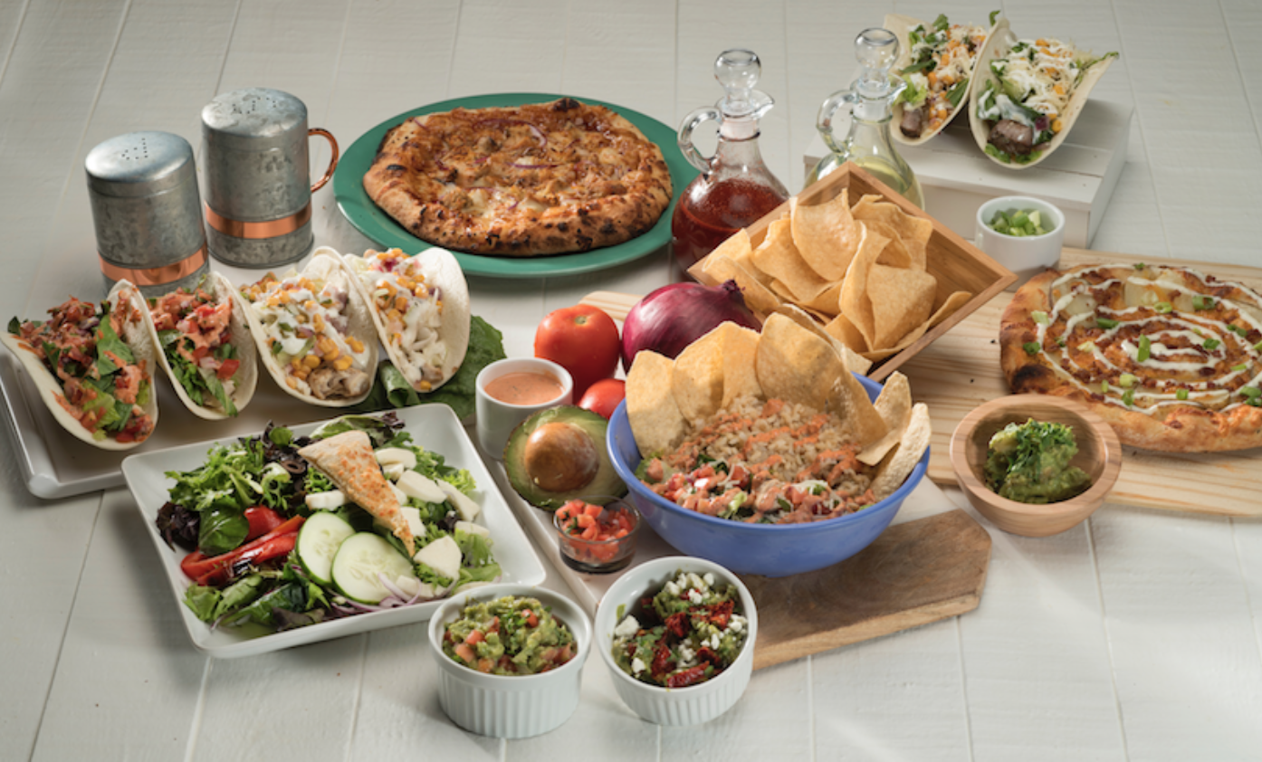Assorted salads, tacos, and pizzas; image by Randy Fath, via Unsplash.com.