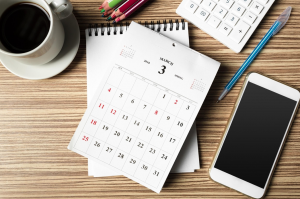 Desk with calendar, phone, cup of coffee; licensed by owner.